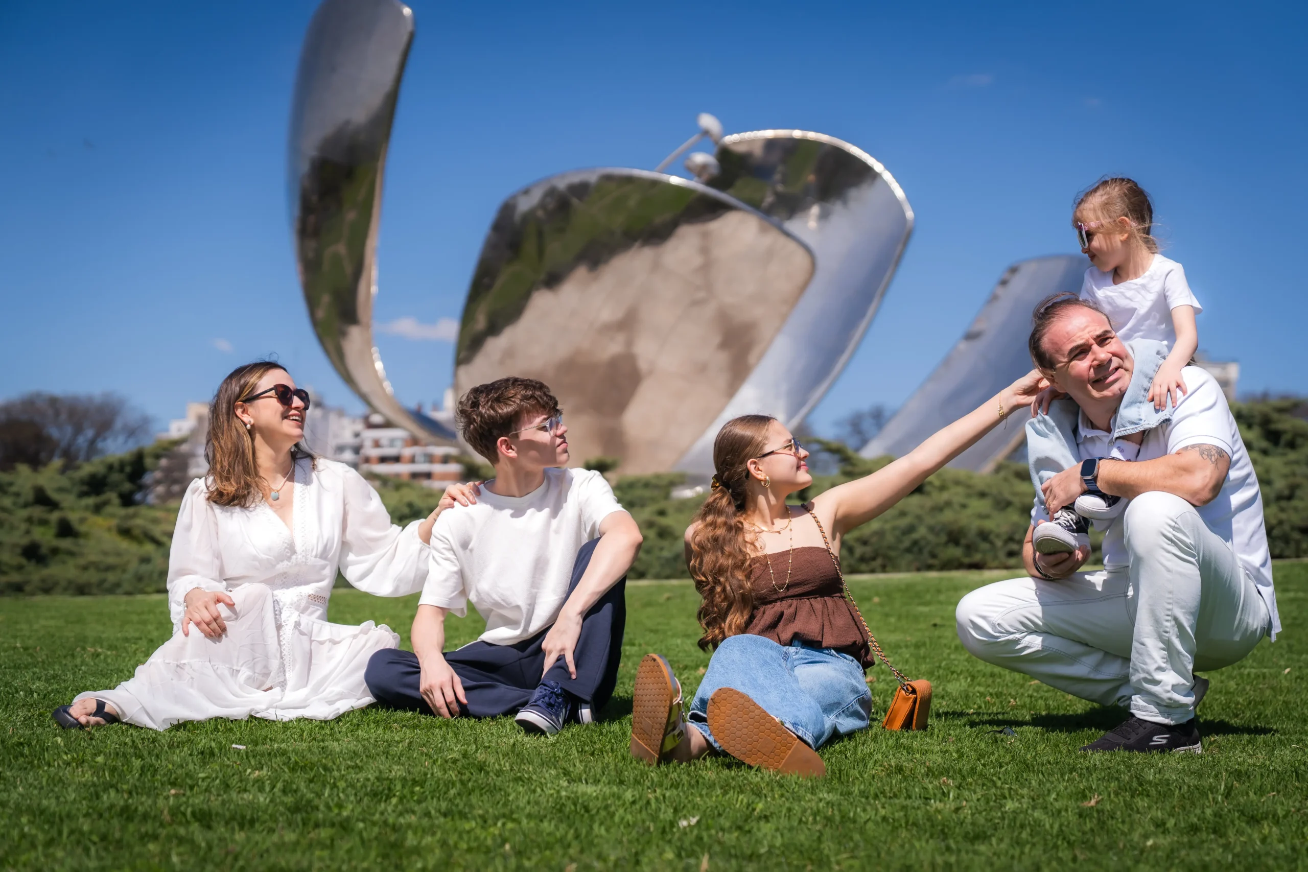 Família posando para fotos em frente à Floralis Genérica, em Buenos Aires.
